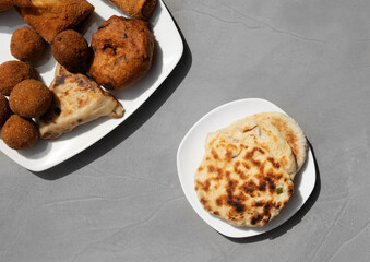 Authentic Sri Lankan different street food, short eats. Vegetable roti, Chinese Rolls , coconut roti, cutlets, mutton rolls on gray background. Snacks made with tuna, potatoes, onion and deep fried