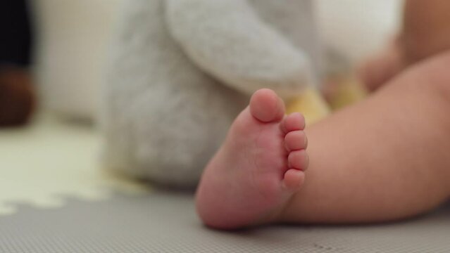 Closeup shot of a baby boy's foot while he plays with toys