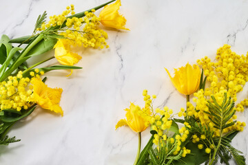 Frame wreath made of yellow tulip flowers on marble background. Flat lay