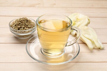 Aromatic fennel tea, seeds and fresh vegetable on wooden table, closeup