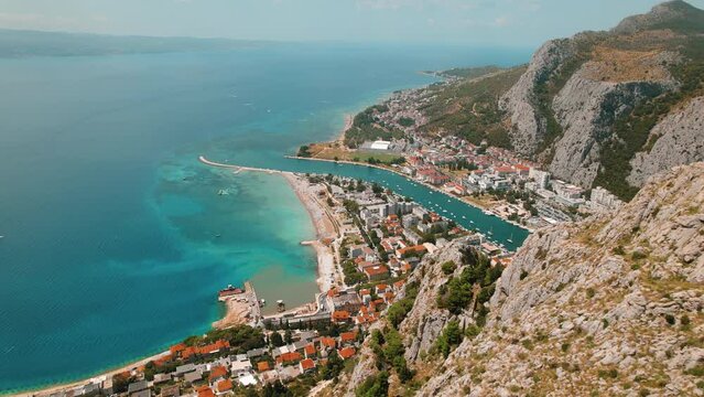 Aerial view of Coastal Fortification Overlooking Omis Town in Croatia. Historic fortress presides over the landscape with urban area and azure sea.