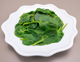 Fresh green baby Spinach leaves, diet and health concept, weight loss, spinach on ceramic plate,...