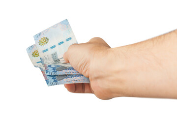 Hand-holding Saudi banknotes isolated on a white background.