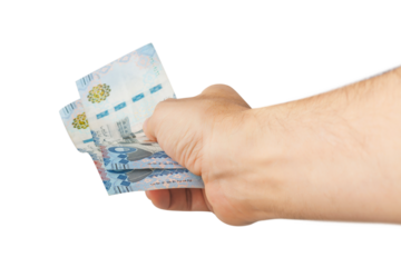 Hand-holding Saudi banknotes isolated on a white background.