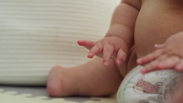 Baby boy with a bumble bee backpack sitting on the floor playing with his toys