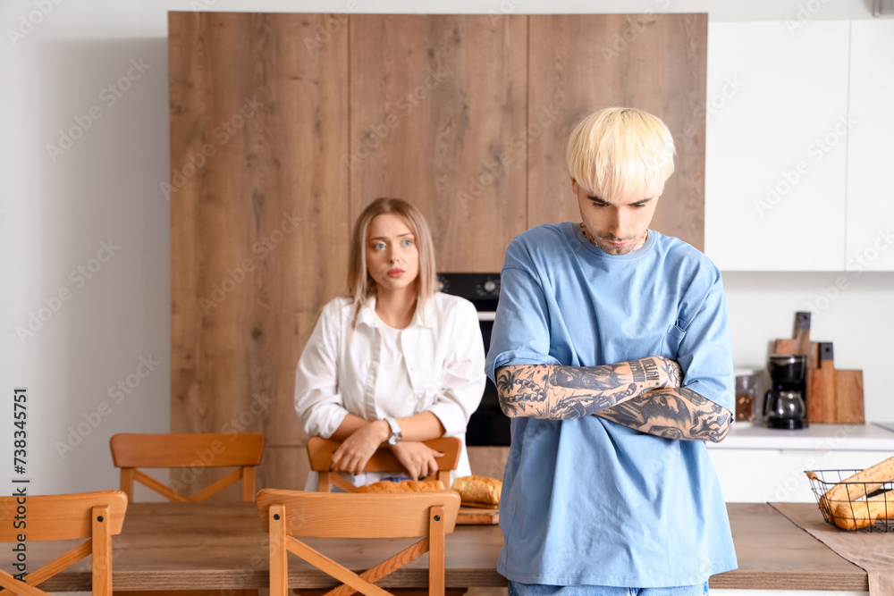 Sticker Offended young man with his girlfriend in kitchen