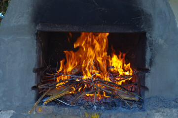 Burning wood produces a fire in a barbecue site