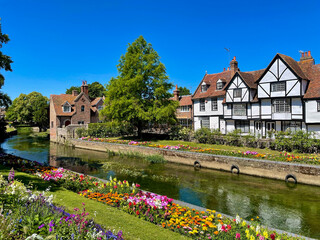 Colourful array of blooming flowers and charming old houses by the River Stour