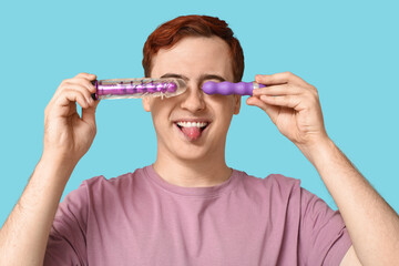 Funny young man with vibrators on blue background