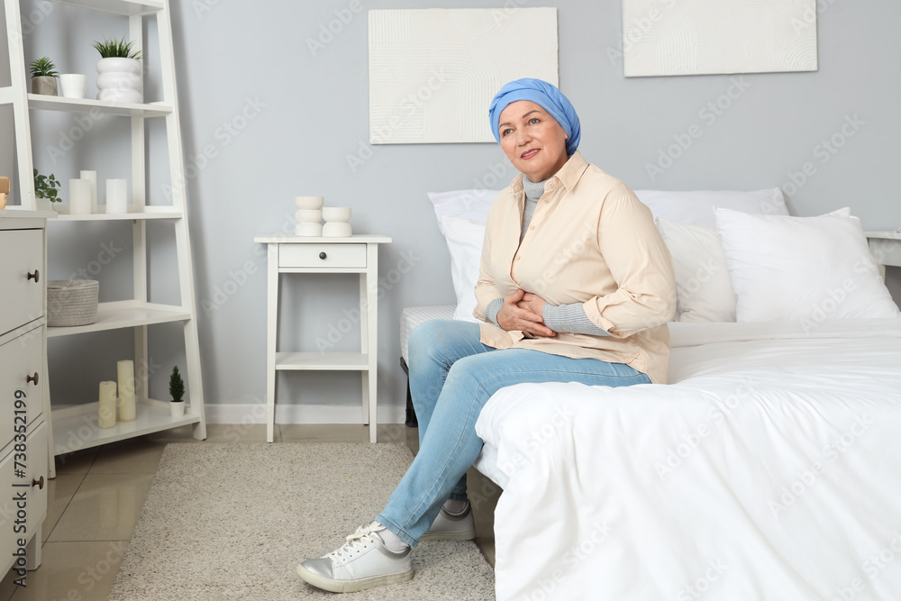 Poster Mature woman after chemotherapy sitting in bedroom. Stomach cancer concept