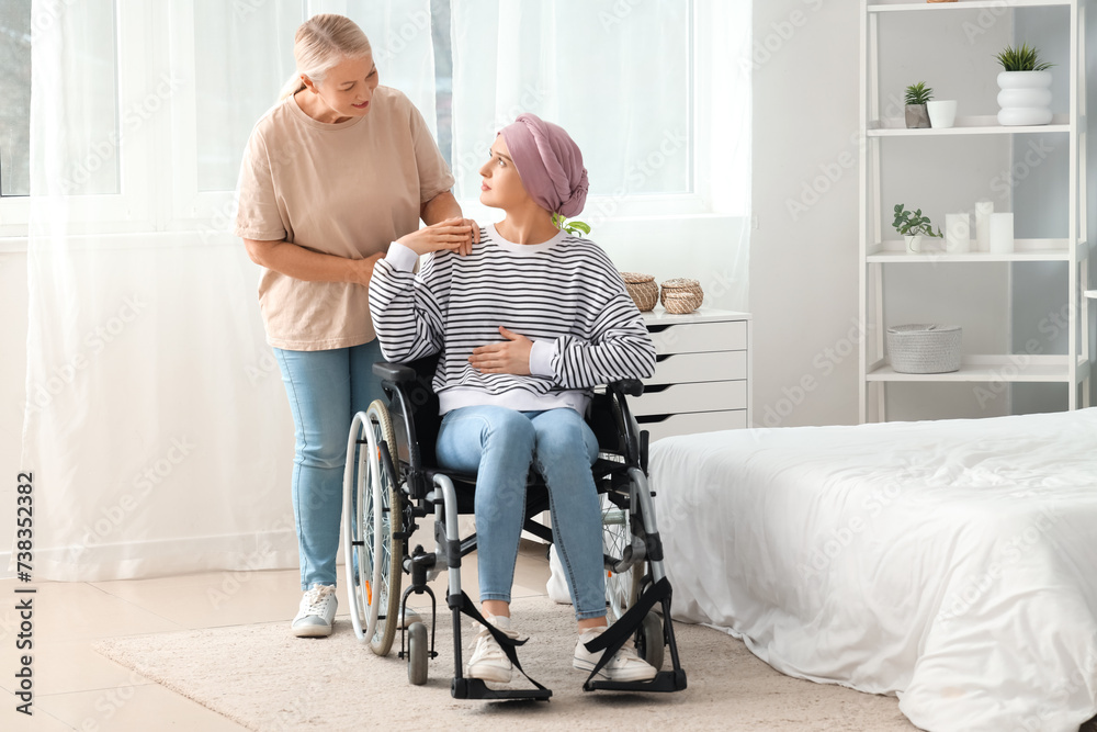 Poster young woman after chemotherapy in wheelchair with her mother at home. stomach cancer concept