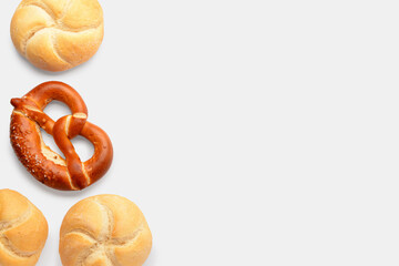 Fresh delicious pretzel and kaiser rolls on white background