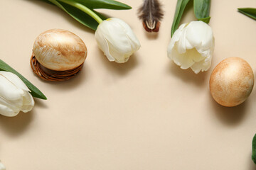 Easter eggs with tulips and feather on beige background
