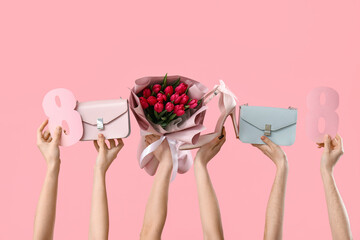 Female hands with bouquet of tulips, handbags and paper figures 8 on pink background. Shopping for...