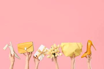 Female hands with bouquet of tulips, handbags and high heel shoes on pink background. Shopping for International Women's Day - obrazy, fototapety, plakaty