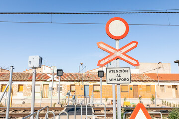 Road sign closed to vehicle traffic and unguarded level crossing sign in front of a railway crossing - obrazy, fototapety, plakaty