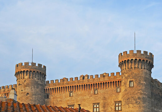 Two towers of the Orsini Castle (Castello Orsini Odescalchi) in Bracciano, Italy with a blue and white sky on an early evening in spring
