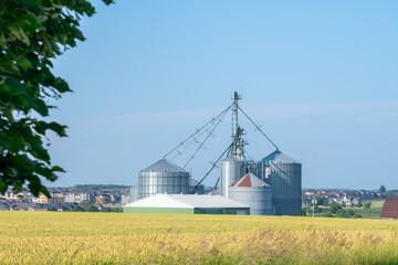 Ripen yellow wheat field and mill plant during summer in the Canadian countryside. View of...