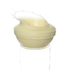 Tofu Soybean soymilk pour fall down. Soybean milk or cosmetic cream moisturizer spill splash in shape glass bowl as paint color. White background isolated high speed shutter freeze motion