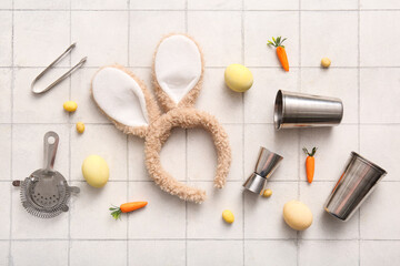 Bunny ears with Easter eggs and bartender supplies on white tiled background