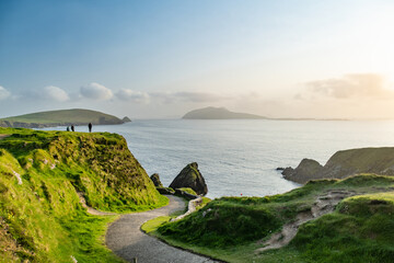 Dunquin or Dun Chaoin pier, Ireland's Sheep Highway. Narrow pathway winding down to the pier, ocean...