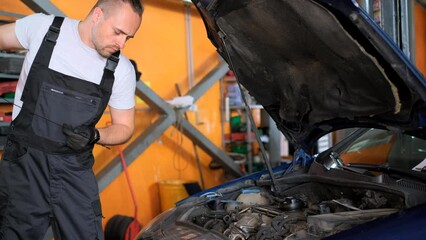 Mechanic working on car in garage automotive repair concept