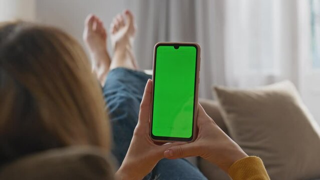 Lady reading green screen smartphone at home closeup. Relaxed girl using phone