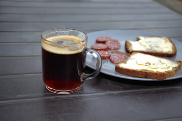 Brotzeit mit Tasse Kaffee, Butterbrot und Salami.