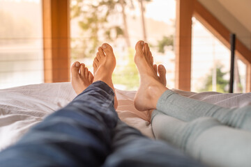 Couples feet relaxing in bed on a morning weekend 