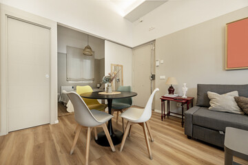 Small loft-style home with a circular dining table, gray painted walls and light parquet floors