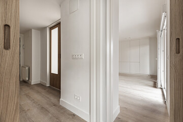 Rooms of a recently renovated empty house with plain white painted walls and light wooden floors