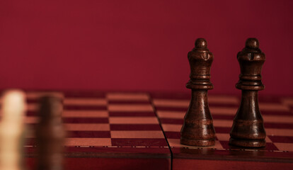chess pieces on a wooden board two black queens