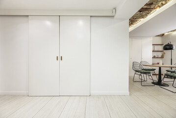 White wooden sliding doors to a room in an industrial loft apartment.