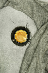 Central image of a freshly poured cup of coffee on a gray surface.