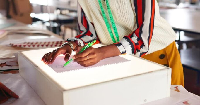 Hands, fashion drawing and tailor in office for clothes style on light box closeup. Paper, creative and clothing sketch with professional designer in studio or workshop for textile production