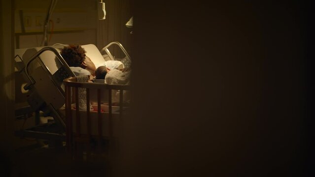 Black Woman with Curly Hair Resting in Delivery Room With Infant Child