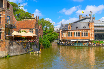Fototapeta na wymiar Picturesque historic buildings with outdoor patios and cafes along the scenic River Leie in the historic center of the medieval old town of Ghent, Belgium.