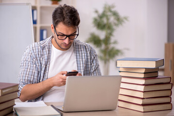 Young male student preparing for exams in the classroom