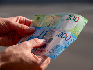 Hand Holding 200 and 2000 Russian Ruble Banknotes