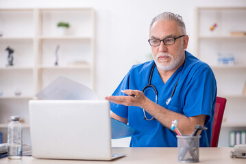 Old male doctor in telemedicine concept