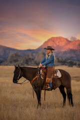 Wyoming Cowgirl on horse with alpenglow mountains