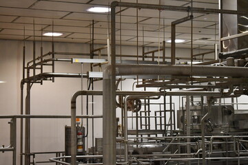 Stainless steel piping hanging from factory ceiling.
