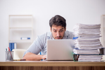 Young male employee and too much work in the office