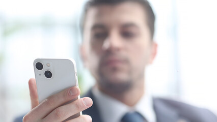 Obraz na płótnie Canvas A male businessman uses a phone in close-up