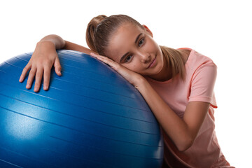 Close up portrait of a slim teen girl holding a swiss blue ball. Shot on white background