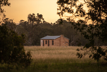 Obraz premium Homestead at Perrys Paddock, Perth Western Australia amongst trees and wide open field. Concept of old house, history, nature, time, old, sunset, outdoors, nature, fields