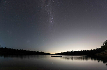 Milky Way tail and starry night at Lake Leschenaultia, Perth Western Australia on a still night. Light pollution in the horizon, trees, water, lake, stars, astro, astrophotography