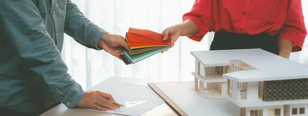 Female architect interior designer send color swatches to project manager for choosing an...