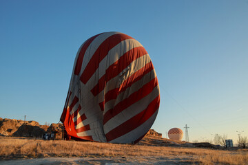 Hot air balloon ready to fly against the blue cloudless sky