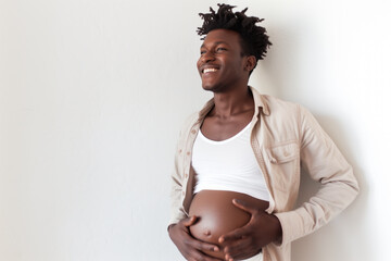 A pregnant, black, transgender African American man holding his belly against a white background with room for text.  - obrazy, fototapety, plakaty